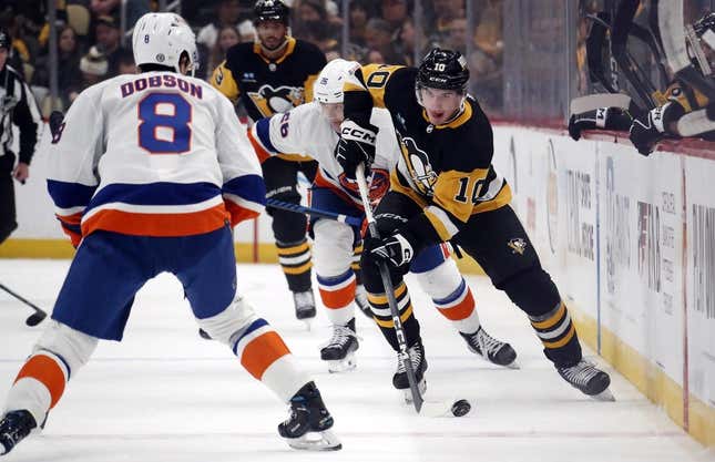 20. Februar 2024;  Pittsburgh, Pennsylvania, USA;  Der linke Flügel der Pittsburgh Penguins, Drew O'Connor (10), läuft mit dem Puck über das Eis, während der New York Islanders-Verteidiger Noah Dobson (8) im ersten Drittel in der PPG Paints Arena verteidigt.