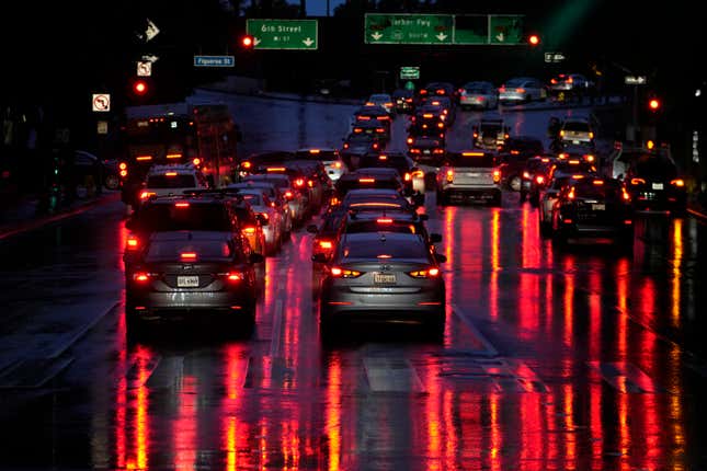 FILE - Car lights are reflected in the wet street as commuters line up in traffic to enter the I-110 Harbor freeway in the rain in downtown Los Angeles, March 6, 2024. Most electronic systems that take on some driving tasks for humans don’t adequately make sure drivers are paying attention, and they don’t issue strong enough warnings to make drivers behave. That&#39;s according to an insurance industry study published Tuesday, March 12, 2024. (AP Photo/Damian Dovarganes, File)