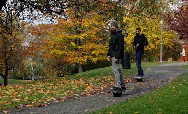 File - Two people ride Onewheels through Wright Park in Tacoma, Wash., on Oct. 26, 2018. All models of Onewheel self-balancing electric skateboards are under recall after at least four deaths and multiple injuries were reported in recent years, federal regulators said last week.(AP Photo/Ted S. Warren, File)