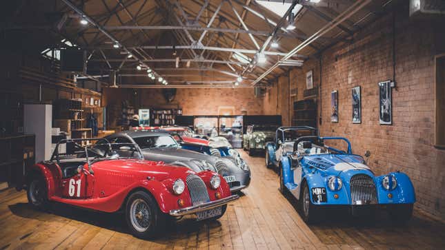 A photo of several brightly-colored Morgan sports cars in a showroom. 