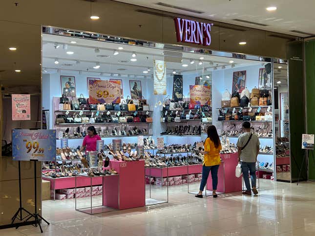 People shop at a Vern&#39;s outlet at a shopping mall in Kuala Lumpur, Malaysia, Monday, April 8, 2024. Vern’s Holdings, a Malaysian shoe company has apologized and stopped selling some of its footwear after some Muslims said the logo resembled the Arabic writing for the word God. (AP Photo/Vincent Thian)