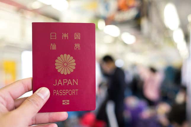 A hand holding up Japan's passport