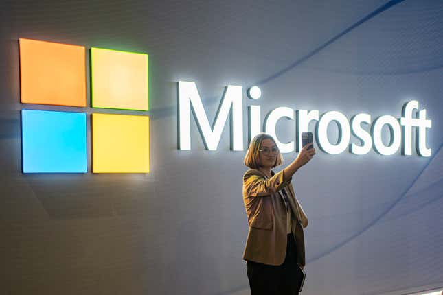 FILE - A visitor takes a photo at the Microsoft stand at Mobile World Congress 2024 in Barcelona, Spain, Feb. 27, 2024. New European Union rules aimed at preventing tech companies from dominating digital markets will change what people see online starting Thursday, March 7, 2024. (AP Photo/Pau Venteo, File)