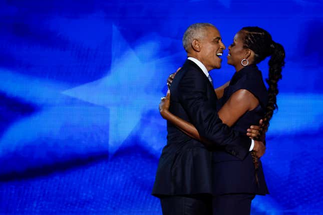 Der ehemalige US-Präsident Barack Obama (links) begrüßt die ehemalige First Lady Michelle Obama, als diese am 20. August 2024 am zweiten Tag des Democratic National Convention im United Center in Chicago, Illinois, auf der Bühne ankommt, um dort zu sprechen. 