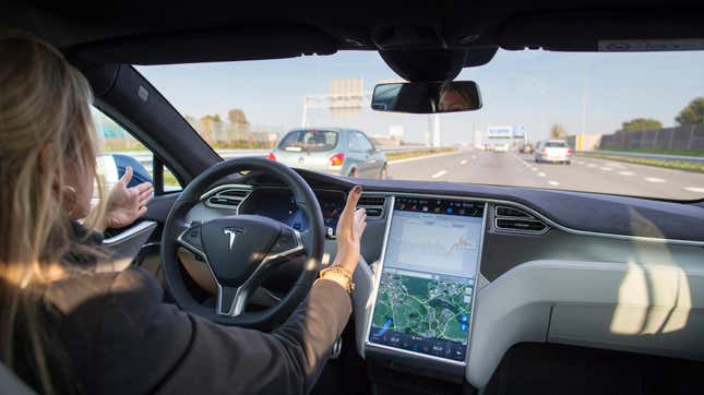 A blonde woman in the driver seat of a Tesla travels down a sunny three lane highway with her hands off, but right next to, the steering wheel. Traffic ahead of her is light. A blue car is in the passing lane ahead of her and a silver car is much farther ahead in the right lane. No cars are in front of her. 