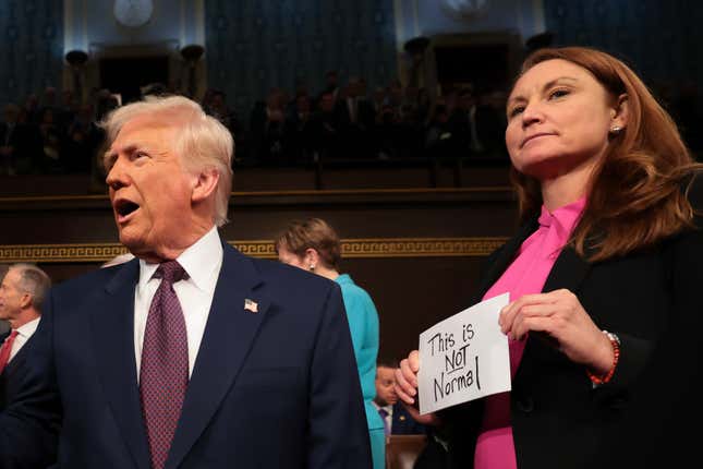 WASHINGTON, DC - MARCH 04: U.S. President Donald Trump arrives for his speech to a joint session of Congress as Rep. Melanie Stansbury (D-NM) holds a sign reading “This is not normal” at the U.S. Capitol on March 04, 2025 in Washington, DC. 