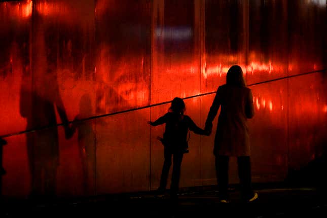 FILE - A woman and child walk as light rain falls in downtown Kansas City, Mo., on March 7, 2024. Tax pros say there are a few tips parents should keep in mind when filing their tax returns this year. (AP Photo/Charlie Riedel, File)