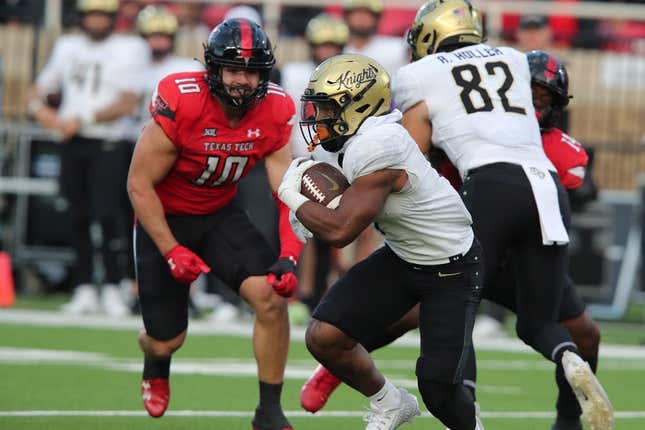 Nov 18, 2023; Lubbock, Texas, USA;  Central Florida Knights running back RJ Harvey (7) rushes against Texas Tech Red Raiders defensive end Jacob Rodriguez (10) in the first half at Jones AT&amp;amp;T Stadium and Cody Campbell Field.