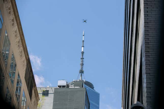 FILE - An NYPD or FDNY drone flies over the site of a partially collapsed parking garage as One World Trade Center is visible in the background in New York City, April 19, 2023. The New York City police department plans to pilot the unmanned police surveillance drones in response to complaints about large gatherings, including private events, over Labor Day weekend, officials announced Thursday, Aug. 31. (AP Photo/Ted Shaffrey, File)