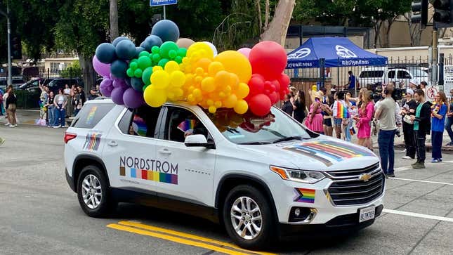 Ein weißer Chevrolet Traverse mit Regenbögen und Luftballons auf dem Dach