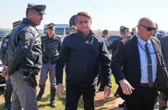 Brazilian President Jair Bolsonaro surrounded by military and security officials.