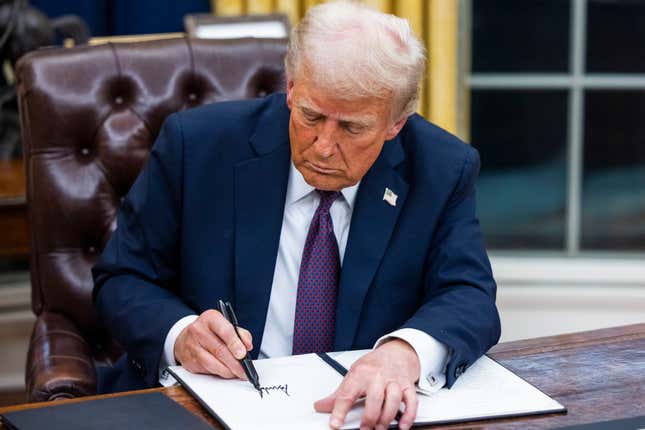 Donald Trump signs executive orders in the Oval Office of the White House in Washington, DC, US, on Monday, Jan. 20, 2025.