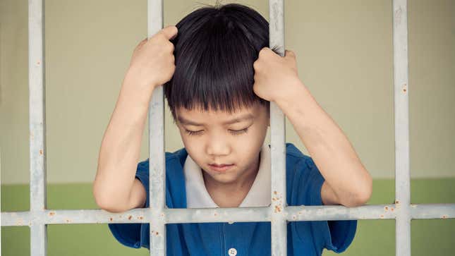 A photo shows a young kid locked in a jail cell. 
