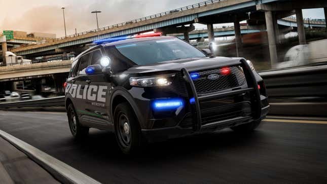 A ford police interceptor with its lights on driving on a freeway