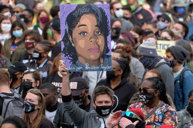 A protestor brandishes a portrait of Breonna Taylor during a rally in remembrance on the one year anniversary of her death in Louisville, Kentucky on March 13, 2021