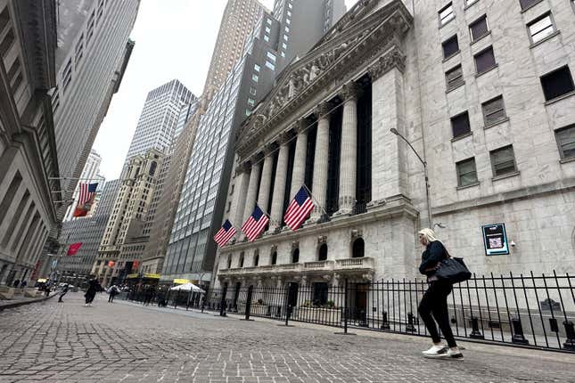 A person passes the New York Stock Exchange on Tuesday, April 30, 2024 in New York. Global shares are trading mostly higher as investors keep their eyes on potentially market-moving reports expected later this week. (AP Photo/Peter Morgan)