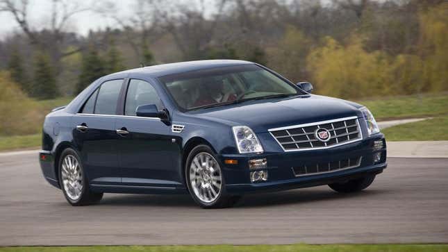 Une Cadillac STS bleue roulant sur une piste 