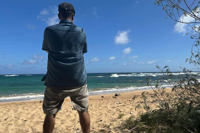 Antonio Perez looks out at Kawailoa Bay in Kauai, Hawaii on Nov. 5, 2023. “I was suicidal before I got into conspiracy theories,” said Perez, who became obsessed with Sept. 11 conspiracy theories and QAnon until he decided they were interfering with his life. Back then, when he first found other online conspiracy theorists, he was ecstatic. “It’s like: My God, I’ve finally found my people!” (AP Photo/Eugene Garcia)