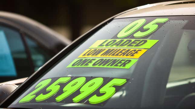 Stickers on the windshield of a car for sale at a used car dealership