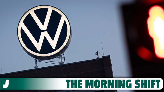 Das VW-Logo leuchtet am frühen Morgen hinter einer roten Ampel auf dem Dach des Markenturms im Volkswagen-Stammwerk. Volkswagen hat angekündigt, aufgrund der angespannten Lage der Kernmarke seinen Sparkurs zu verschärfen. 