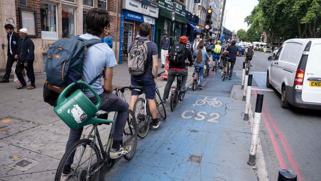 Line of cyclists waiting at the lights on a cycle lane superhighway in Whitechapel on 27th June 2022 in London, United Kingdom.