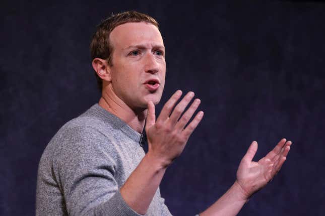 Mark Zuckerberg, META CEO, holds his hands up as he speaks to an audience.