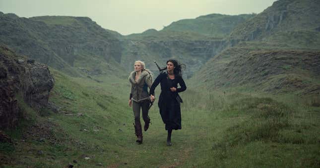 Ciri and Yennefer running hand-in-hand while Yennefer carries a sword on her back.