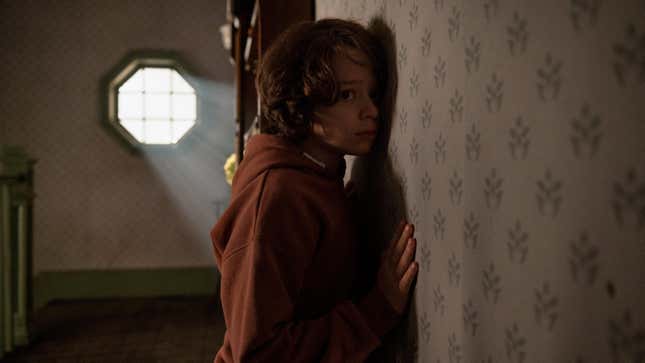 A boy presses his ear to the wall in Cobweb