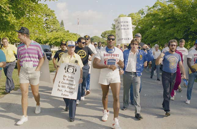 Dan Marino (left, striped shirt) and several Miami Dolphins players and their supporters out picketing. (Raul Demolina/AP Photo)