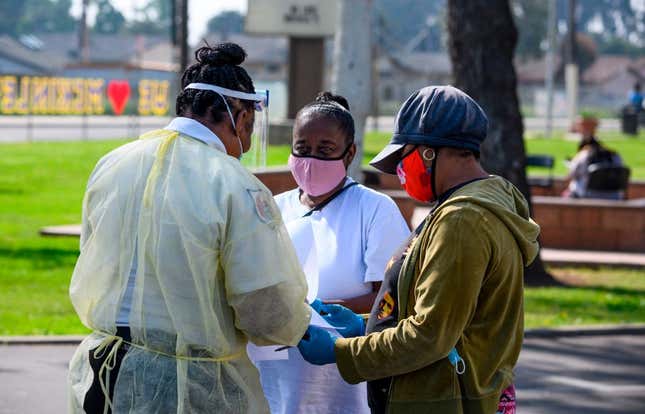 Local residents fill out paperwork at a mobile COVID-19 testing station by St. John’s Well Child and Family Center on April 28, 2020. 