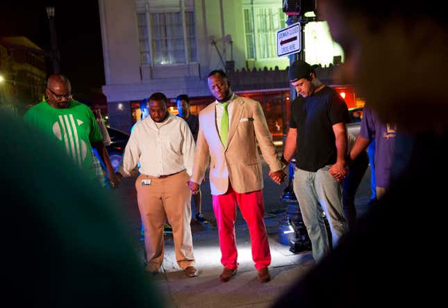 Worshippers gather to pray down the street from the Emanuel AME Church following a shooting Wednesday, June 17, 2015, in Charleston, S.C. (AP Photo/David Goldman)