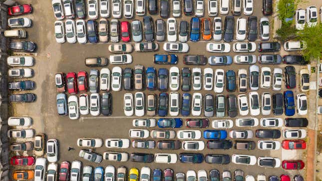 An aerial overhead view of cars packed into a parking lot