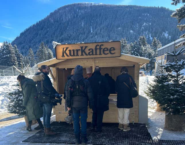 People wait for hot beverages from the KurKaffee coffee hut in Davos, Switzerland