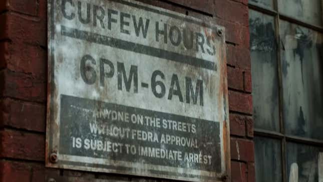 A sign indicating strict curfew enforcement hangs on a brick wall.