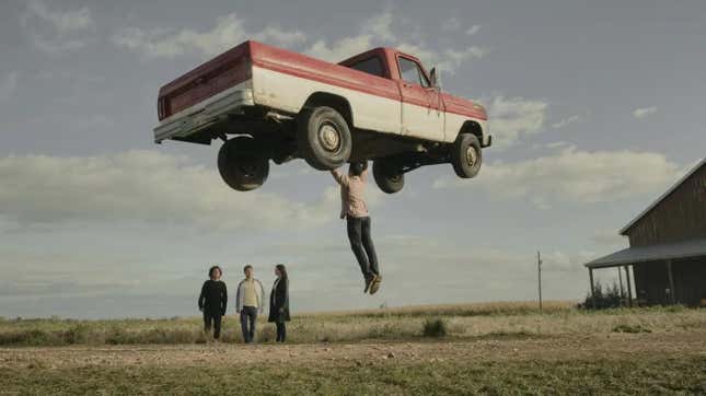 Superman on a farm, lifting a truck in front of his family