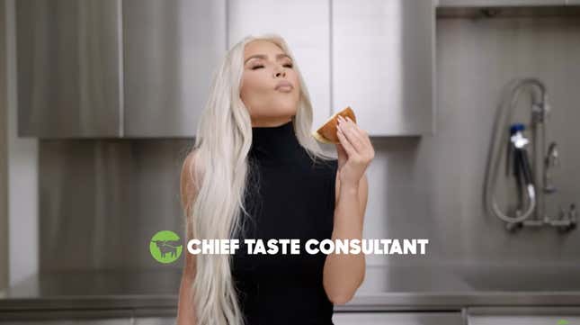 Kim Kardashian closing her eyes, savoring a burger she clearly hasn't taken a bite out of