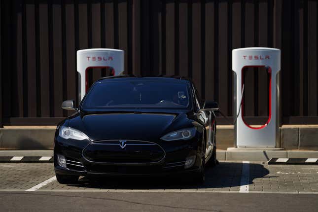 Tesla parked outside and connected to a Supercharger