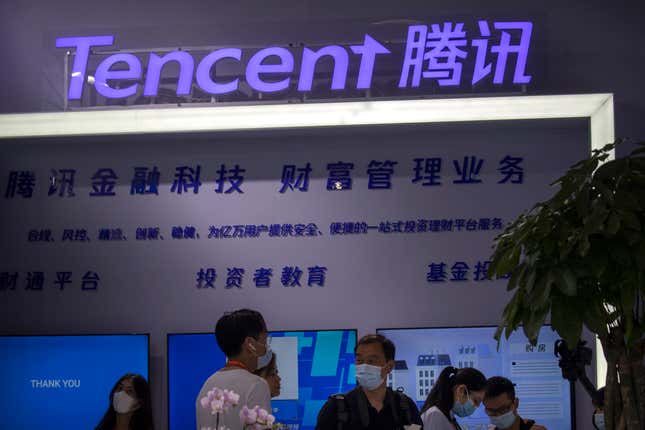 people look at a display from Chinese technology firm Tencent at the China International Fair for Trade in Services