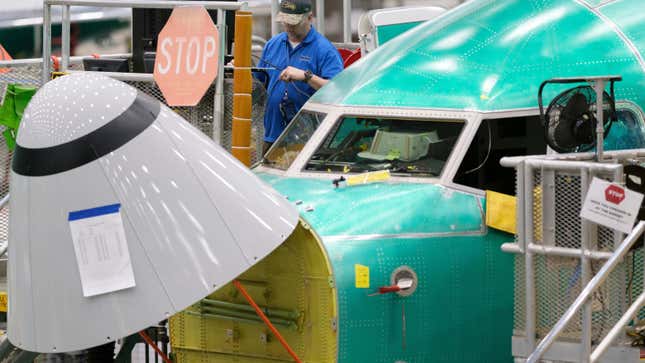 A Boeing factory worker working outside the cockpit of a 737 Max 8 under production at the company's Renton, Washington plant in March 2019.