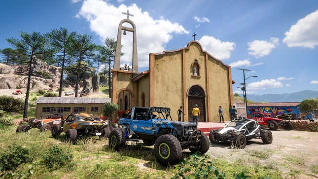 A bunch of offroad vehicles are parked in front of a church.