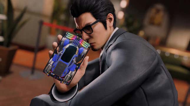 Kiryu holds a race car.