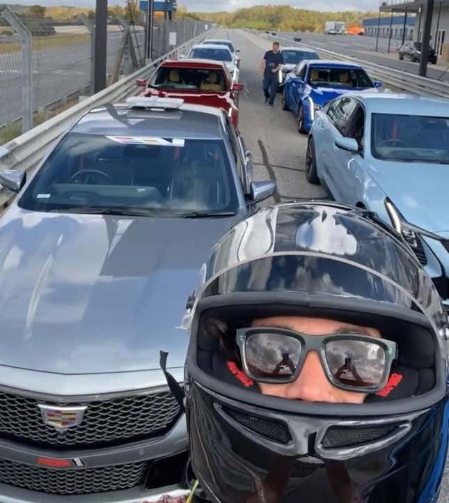 a photo of me wearing a helmet in front of a lineup of Cadillac CT5 V Blackwings on a track