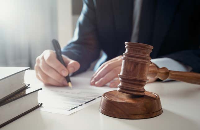 Lawyer writing next to a gavel