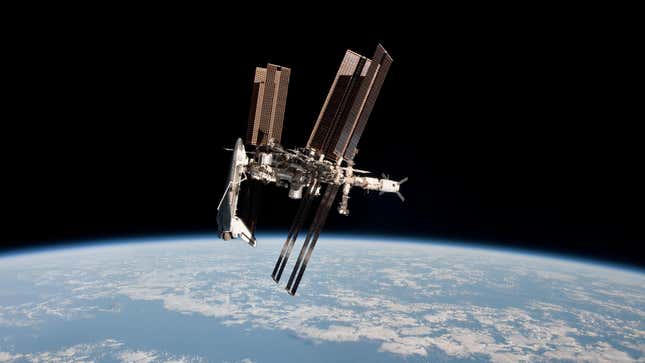 The international space station hovering in low earth orbit in front of a background of the earth and the deep black of space. A space shuttle is attached to one end of the station.