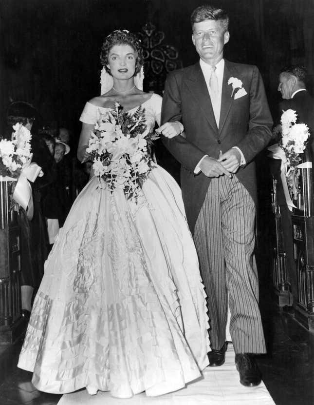 Senator John Fitzgerald Kennedy (1917 - 1963), Democratic senator for Massachusetts, escorts his bride Jacqueline Lee Bouvier (1929 - 1994) down the church aisle shortly after their wedding ceremony at Newport, Rhode Island.