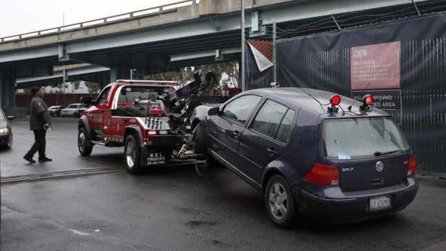 Une photo d’une dépanneuse emmenant une voiture vers une fourrière. 