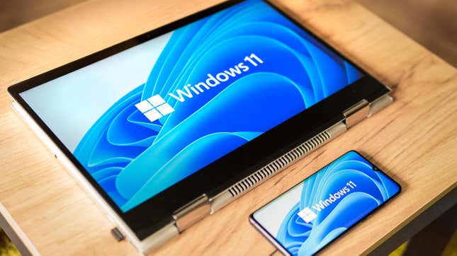 Windows 11 logo on the screens of a transformer laptop and a modern smartphone