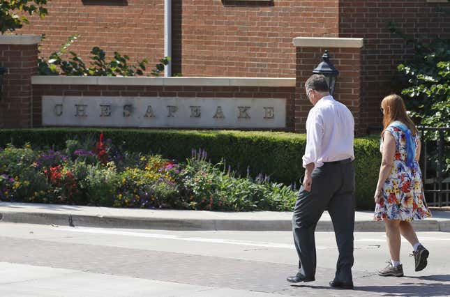 FILE - Two people walk past one of the entrances to the Chesapeake Energy Corporation campus in Oklahoma City, Tuesday, Sept. 29, 2015. Chesapeake Energy and Southwestern Energy are combining in a $7.4 billion all-stock deal, Thursday, Jan. 11, 2024 to form one of the biggest natural gas producers in the U.S. (AP Photo/Sue Ogrocki, File)