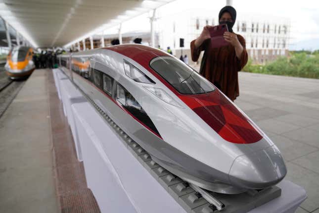 FILE - A woman to take photos of a model high-speed train at the Jakarta-Bandung Fast Railway station in Tegalluar, West Java, Indonesia, Thursday, Oct. 13, 2022. Chinese Premier Li Qiang has taken a test ride on Southeast Asia’s first high-speed railway, which connects two Indonesian cities as part of China’s Belt and Road infrastructure initiative. Li is visiting Jakarta for two days of talks with leaders of the Association of Southeast Asia Nations and other countries. (AP Photo/Dita Alangkara, File)