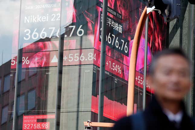 A person walks in front of an electronic stock board showing Japan&#39;s Nikkei 225 index at a securities firm Thursday, Feb. 8, 2024, in Tokyo. (AP Photo/Eugene Hoshiko)